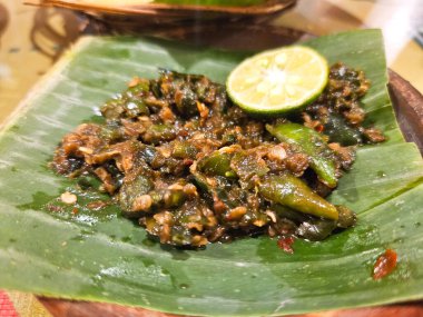 Sambal lombok ijo ya da muz yapraklı kireç tabakta yeşil biber sosu, geleneksel Endonezya gıda kavramı.