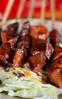 Sate kambing ya da kuzu satay ya da keçi eti dilimlenmiş lahana, domates, soya sosu ve kırmızı biber ile servis edilen satay, Endonezya sokak yemeği.