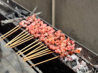 Sate kambing ya da kuzu satay ya da keçi eti dilimlenmiş lahana, domates, soya sosu ve kırmızı biber ile servis edilen satay, Endonezya sokak yemeği.