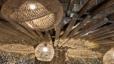 Tavandan sarkan birkaç modern rattan tavan lambası odayı aydınlatıyor. Lambalar, uzaya çağdaş bir dokunuş ekleyerek gösterişli ve şık bir tasarım içeriyor.