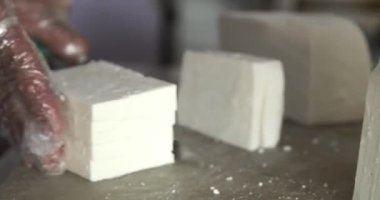 Şefin yetenekli ellerinin peyniri titizlikle dilimlemesini izleyin. Mutfak ustalığı en iyisidir..