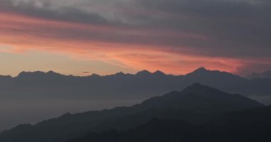 Doğanın nefes kesen manzarasını tecrübe edin. Güneş yükselen dağların ardında batıyor. Gökyüzünü canlı renklerle ve sakin güzelliklerle boyuyor..
