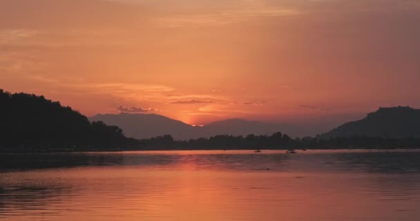 达尔喀什米尔湖 印度在日落后呈红色 经过的船只在水面上产生了反光 夕阳西下 天空一片漆黑 云彩闪烁着背光 — 图库视频影像