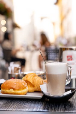 Sabahları bir fincan kapuçino, yanında kruvasan ve kahve.