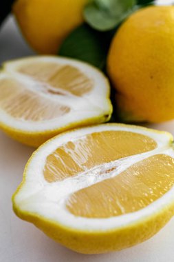 Temiz beyaz bir arka planda sergilenen bir dizi taze limon. Görüntüler canlı sarı rengi ve meyvenin dokusunu vurguluyor. Yemek fotoğrafçılığı, sağlıklı beslenme kavramları ya da ferahlatıcı yaz temaları için mükemmel..