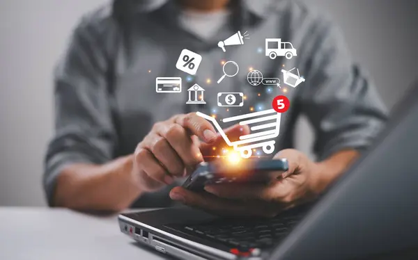 Girişimci ya da müşteri akıllı telefon kullanır, alışveriş arabası simgesi olan dizüstü bilgisayar ürün satın alır. Çevrimiçi alışveriş, e-ticaret teknolojisi internet kavramı. Satış dijital pazarlama stratejisi web