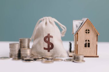 Ev, içinde dolar işareti olan altın madeni paralar ve çanta tasarrufu, emlak konseptine para yatırımı. Kredi ve yatırım, finans, ipotek ve sigorta. Vergi mevsimi, borç tahsilatı, iş ödemesi 