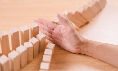 Risk yönetimi kriz konsepti. Emlak işi için finansal analiz çözümü. Elle durdurma ekonomik risk. Tahta blokta risk kelimesi, domino krizi etkisini azaltır. Sigorta güvenlik değerlendirmesi