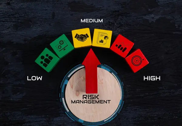 Risk yönetimi konsepti. Risk değerlendirme seviyesi göstergesi derecesi. İş değerlendirmesi ölçüsü. Yeşil üzerine kırmızı ok işareti, sarı renkli tahta blok, yüksek simgeye yakın, siyah arkaplan. Üst görünüm 