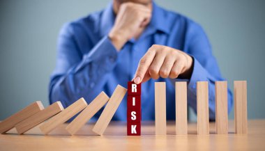 Risk yönetimi kriz konsepti. Emlak işi için finansal analiz çözümü. Elle durdurma ekonomik risk. Tahta blokta risk kelimesi, domino krizi etkisini azaltır. Sigorta güvenlik değerlendirmesi
