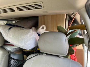 Carrying lots of things in the car, piles of things like box, electronics, plants, home goods clipart