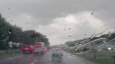 Şiddetli Yağmurlu Hava 'da Fırtınalı Bulutlar Altında Otoyol. Yoğun bir otoyol üzerinde kara fırtına bulutları beliriyor. Arabalar seyahat ediyor ve arka planda yemyeşil bir alan var..