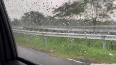 Şiddetli Yağmurlu Hava 'da Fırtınalı Bulutlar Altında Otoyol. Yoğun bir otoyol üzerinde kara fırtına bulutları beliriyor. Arabalar seyahat ediyor ve arka planda yemyeşil bir alan var..