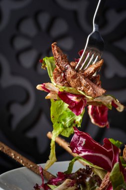 Yapraklı sebze salatasını sığır etiyle kapat.