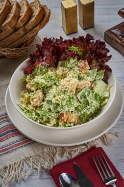 Tahta zeminde tavuklu Sezar salatası tabağı