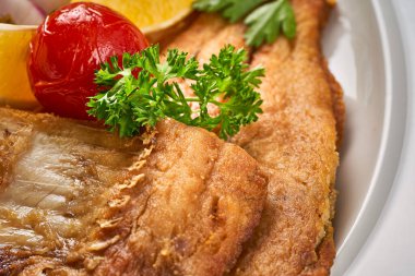 Yakın plan bir porsiyon kızarmış balık pilav ve sebzeli.