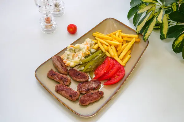 Bir tabak kofta ve patates kızartması.
