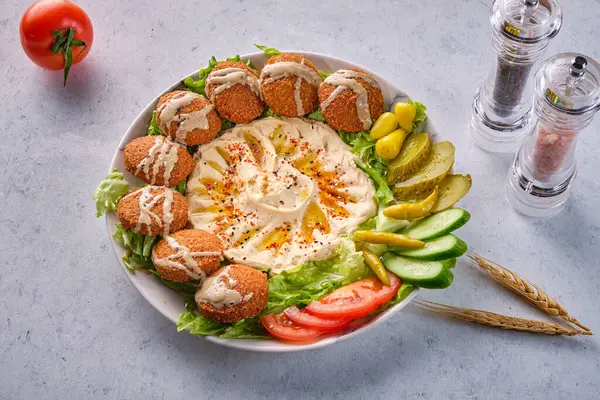 Beyaz arka planda bir tabak nohut ve falafel.