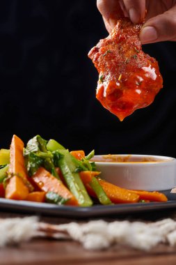 Baharatlı bufalo soslu kızarmış tavuk kanadı ve haşlanmış sebze.