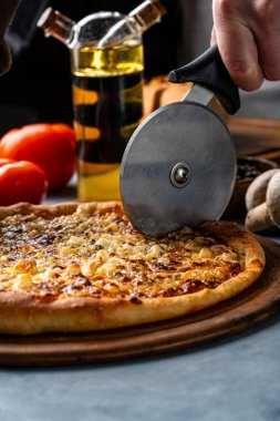 Bir insan tarafından dilimlenmiş sebze ve peynirli pizza.