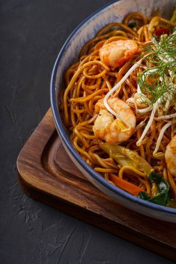 Bir kase eriştenin içindeki bir parça karidesin yakın çekimi.