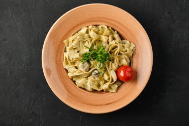 Bir tabak fettuccine alfredo makarnasının üstünde bir fotoğraf.