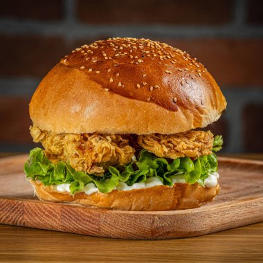 Tahta zeminde kızarmış tavuk burgeri.