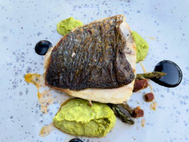 Tabakta yeşil soslu bir balık.