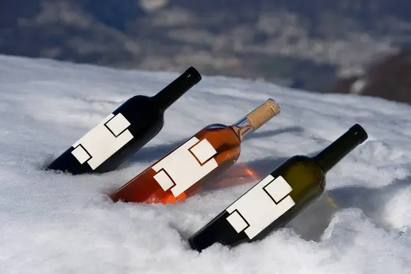 three bottles of wine on a snowy mountain