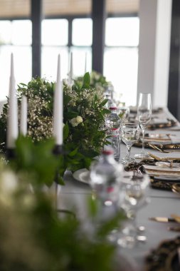 Restorandaki düğün masasında beyaz çiçekli bir masa.