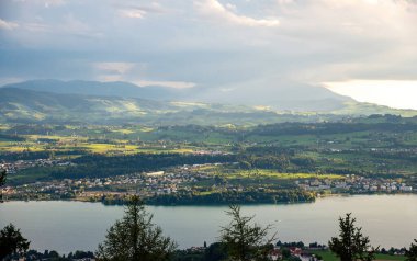 Zurichsee Gölü, akşam güneşiyle dağlara karşı.