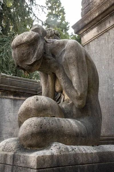 statue of a woman crying in the park
