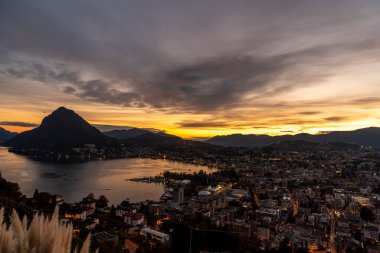 Gün batımı dağların üzerinde ve Lugano Gölü üzerinde, İsviçre