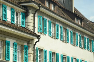 Turkuaz pencere çerçeveli bir binanın ayrıntıları