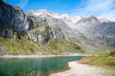 İsviçre Alpleri 'nde küçük bir göl, yüksek Glernisch dağlarıyla çevrili.