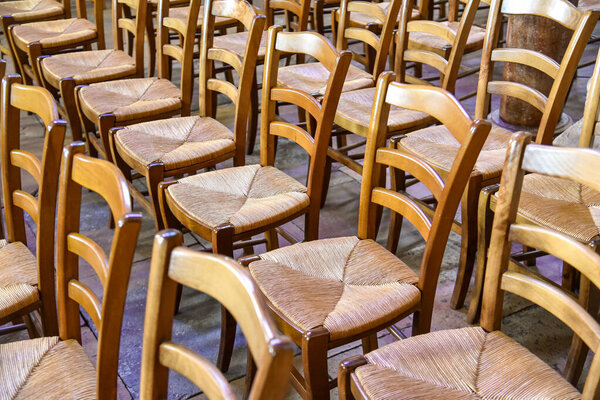ряды старых деревянных стульев в пустой комнате