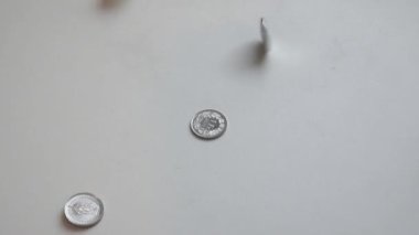 beyaz bir yüzeye düşen yeni paralar