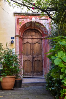 Soluk Kırmızı kemerli Antik Ahşap Kapı Bahçeyle çevrili