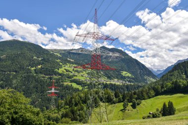 Yüksek voltajlı elektrik hatları Batı Avusturya 'da Innsbruck yakınlarındaki yemyeşil bir Alp Vadisi boyunca uzanıyor.