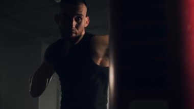 Spor motivasyonu, eski okul spor salonunda sporcu boksunun portresi. Boks çantasıyla güçlü bir adam antrenmanı. Yüksek kalite 4k görüntü