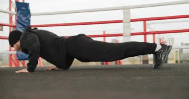 Spor motivasyonu, orta boy bir sporcunun açık hava ringinde şınav çekmesi. Sağlıklı formda adam gücü eğitimi. Yüksek kalite 4k görüntü