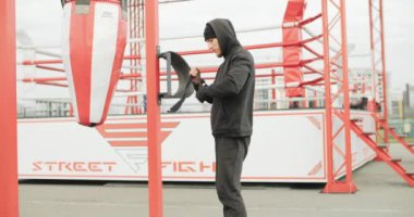 Açık spor salonunda siyah boxer bantları takan güçlü bir boksörün orta boy fotoğrafı. Motivasyon üzerinde çalış. Yüksek kalite 4k görüntü