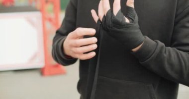 Açık hava spor salonunda siyah boxer bantları takan güçlü bir boksörün yakın çekim görüntüsü. Motivasyon üzerinde çalış. Yüksek kalite 4k görüntü