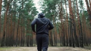 Genç formda sporcu ormanda koşar. Doğada sabah koşusu. Sağlıklı bir yaşam tarzı. Eğitim motivasyonu. Yüksek kalite 4k görüntü