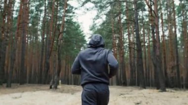 Genç formda sporcu ormanda koşar. Doğada sabah koşusu. Sağlıklı bir yaşam tarzı. Eğitim motivasyonu. Yüksek kalite 4k görüntü