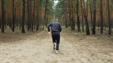 Genç formda sporcu ormanda koşar. Doğada sabah koşusu. Sağlıklı bir yaşam tarzı. Eğitim motivasyonu. Yüksek kalite 4k görüntü