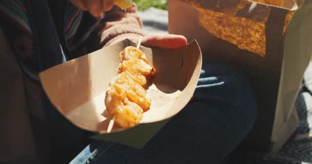 여자는 공원에서 음식을 햇빛을 즐긴다 소녀는 새우를 먹는다 고품질 — 비디오