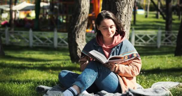 Young Adult Female Reads Book Park Reading Spring Sunlight Girl — Stock Video