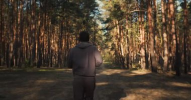 Ormanda koşan genç adam. Maraton antrenmanı. Güneşin doğuşunda açık hava eğitimi. Formda ol. Spor fitness. Yüksek kalite 4k görüntü