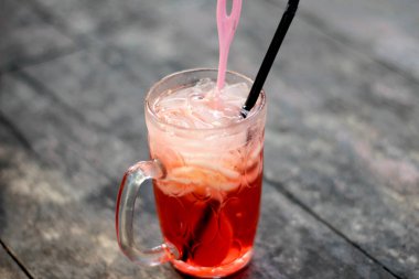 Es Blewah. Endonezya 'nın soğuk meyveli şeritleri ve kokopandan şurubu ahşap bir masada cam bir bardakta servis edilir..